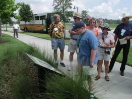 A tour group stops to read an educational sign about conservation practices implemented in the Town of Harmony, Florida. Photo by Mark Hostetler.