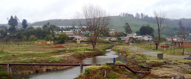 Figure 4. Effects of the tsunami in the urban space of Dichato. The image shows the remaining infrastructure (concrete bathrooms) after the tsunami and the hill at the back. Photo: Paula Villagra