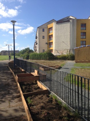 In Clovenstone (Edinburgh), citizens supported by Wester Hailes Edible Estates have begun transforming a small triangle of sad looking grass into a community garden. They will retain the enclosing fence (which can make the area feel helpfully ‘defensible’) but they have also placed raised beds around the perimeter of the fence and have built a step “so that no one hurts themselves climbing over the fence”. Photo: Janice Astbury