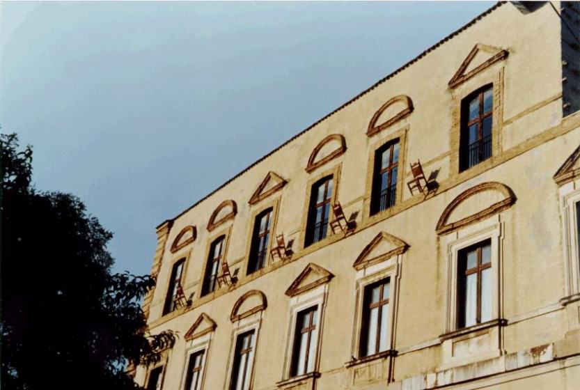 Five town hall chairs hung on the facade of the Palazzo Farnese (Ortona (Ps). Italy.1995. Photo (copyright): Emilio Fantin