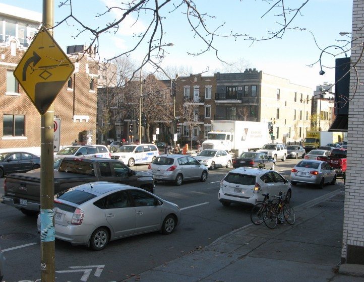 Intersection of two Montréal main streets where heavy vehicular traffic compromises walkability and livability, despite the many dwellings, shops and services lining both streets. Photo: Nik Luka