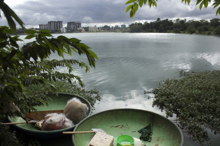 Fishing boats straddle Rachenahalli Lake, across from new residential developments in North Bangalore