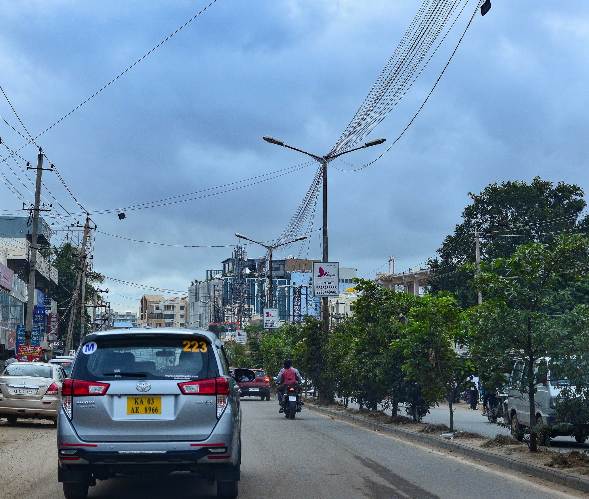 A section of Sarjapur road, at the city periphery, with saplings squeezed into small confines of space, too close to each other, at the median. The only large tree to be seen in the vicinity is a sacred tree to the right of the image, protected within the confines of a temple. Photo credit: Suri Venkatachalam A section of Sarjapur road, at the city periphery, with saplings squeezed into small confines of space, too close to each other, at the median. The only large tree to be seen in the vicinity is a sacred tree to the right of the image, protected within the confines of a temple. Photo credit: Suri Venkatachalam