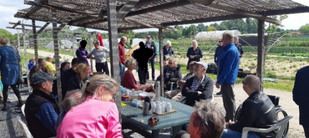 A gathering of people at an outdoor table under an awning