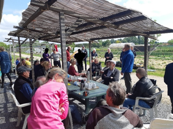 A gathering of people at an outdoor table under an awning