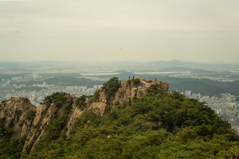 A mountain with a cityscape beyond it