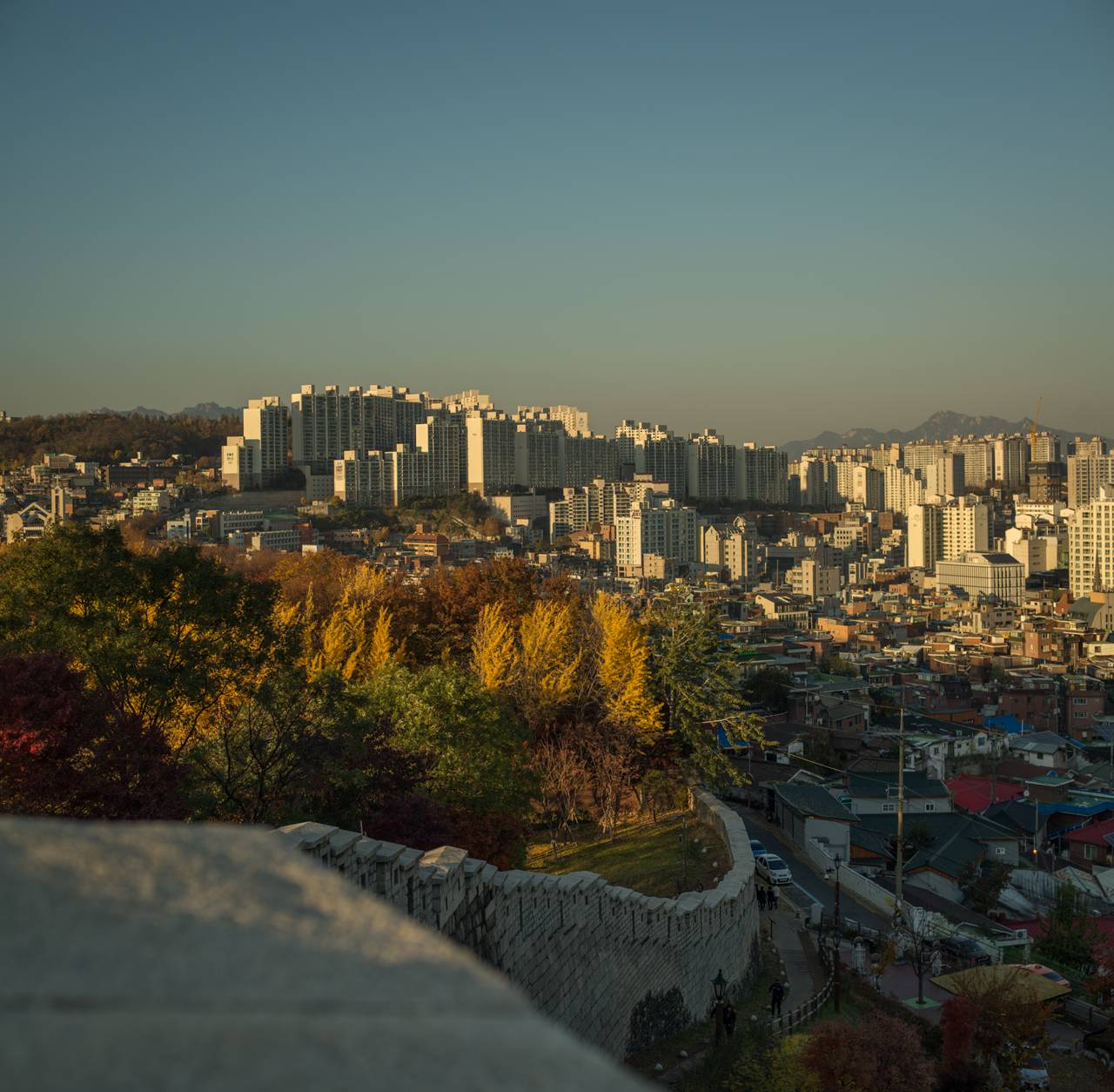 A stone wall with a city in the distance