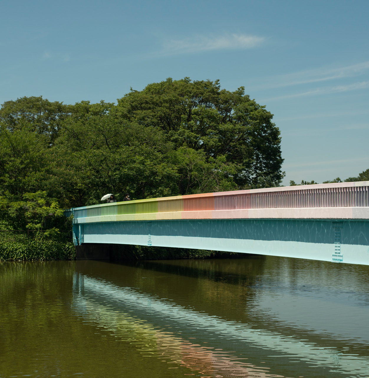 A rainbow striped bridge crossing a body of water