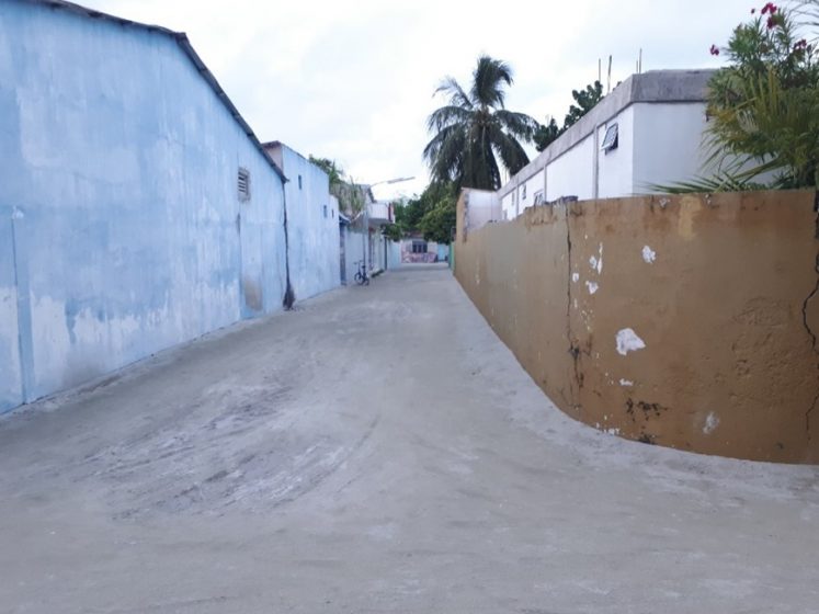 A picture of a sandy alleyway with concrete buildings on either side