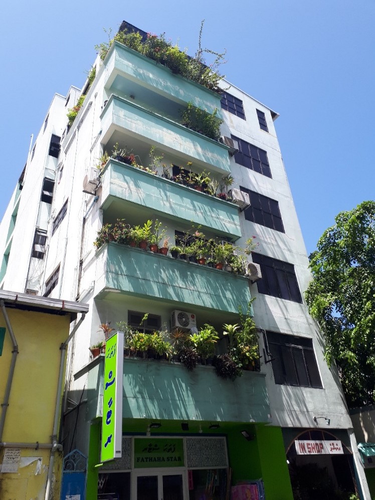 A picture of a residential building with balconies each full of plants