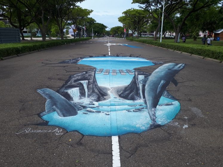 A picture of street graffiti depicting dolphins jumping out of a ravine