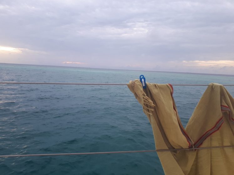 A picture of a scarf clotheslined on a rail overlooking the sea 