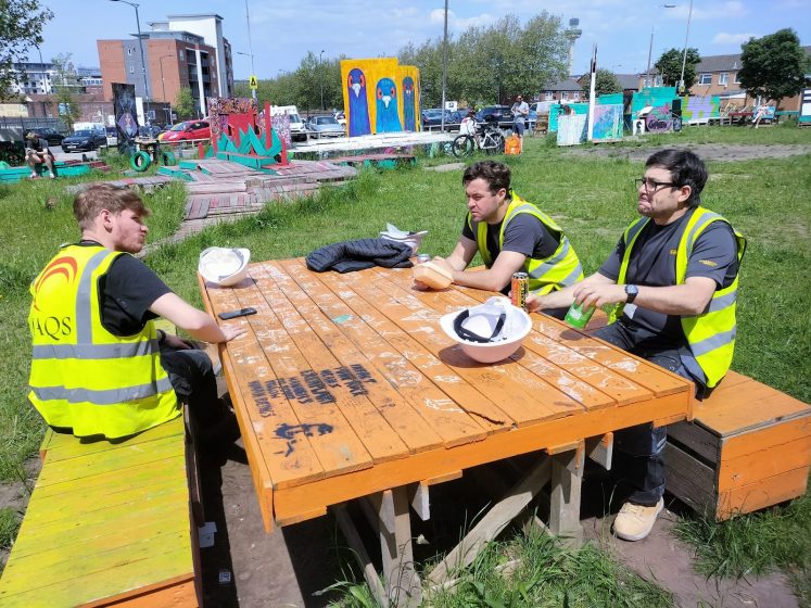 A pictures of a group of workers sitting around a table outside