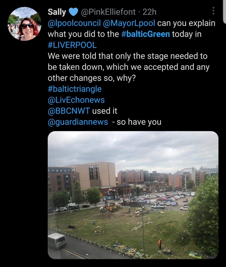 A screenshot of a social media post with a picture of a field, parking lot, and buildings in it