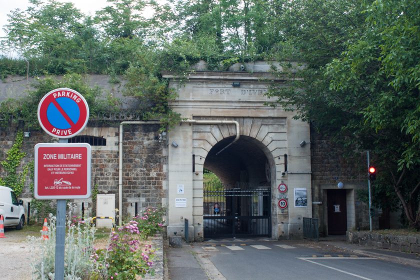 A picture of a stone archway with a gate surrounded by vegetation