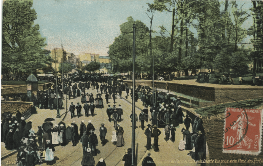 A picture of a group of people standing around on a sidewalk