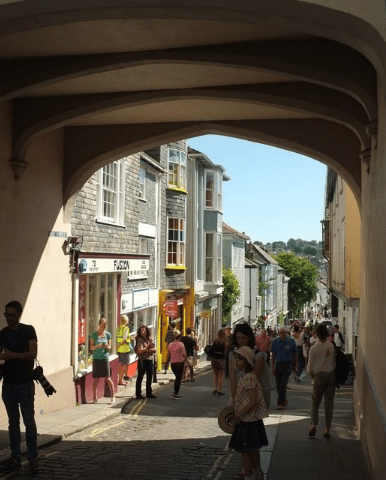 A picture of people walking underneath a bridge