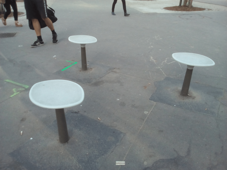 A picture of a sidewalk with metal poles