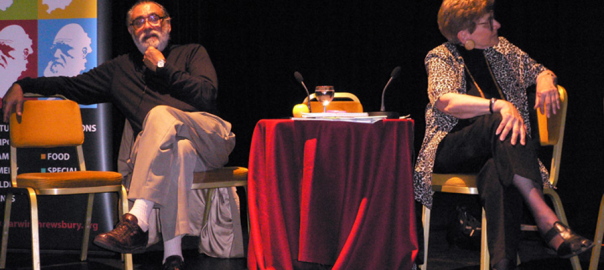 A picture of two people sitting on chairs on a stage