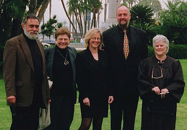 A picture of five people standing outside smiling