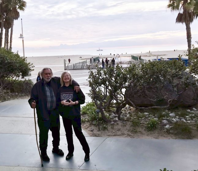 A picture of two people standing in a garden smiling