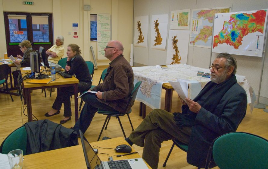A picture of people sitting in a room at desks