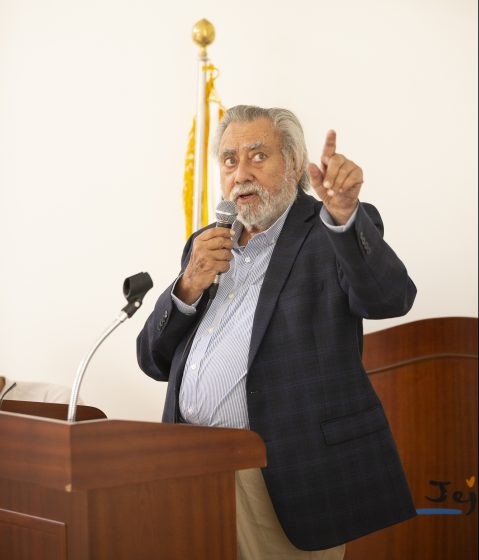 A picture of a man talking into a microphone behind a podium
