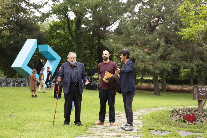 A picture of people standing and talking on a path in a park