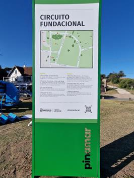 A picture of a sign depicting a map of the area on a beach