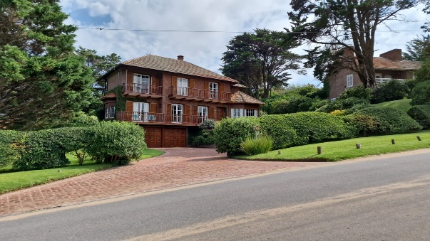 A picture of a brick house with greenery. 