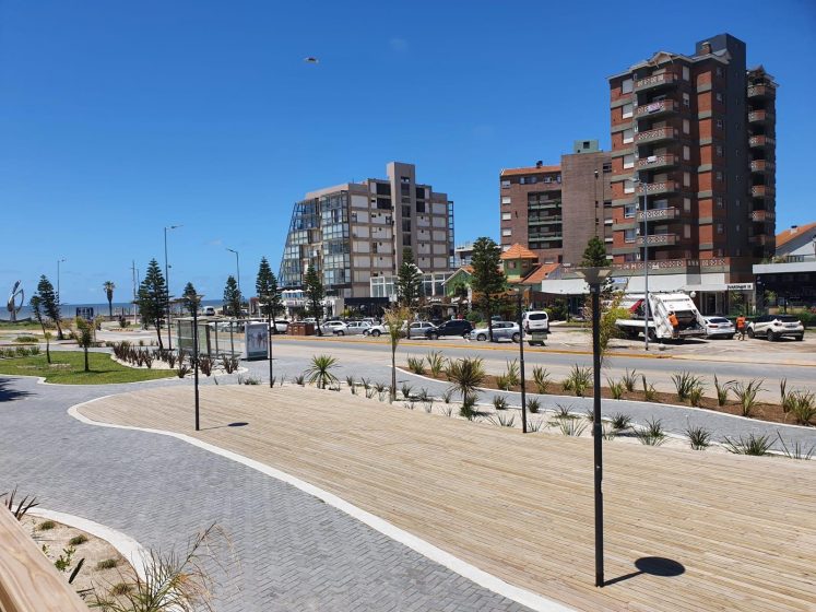 A picture of a road along a beach with buildings in the background