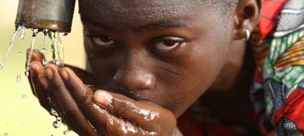 A picture of a young girl drinking water from her cupped hands