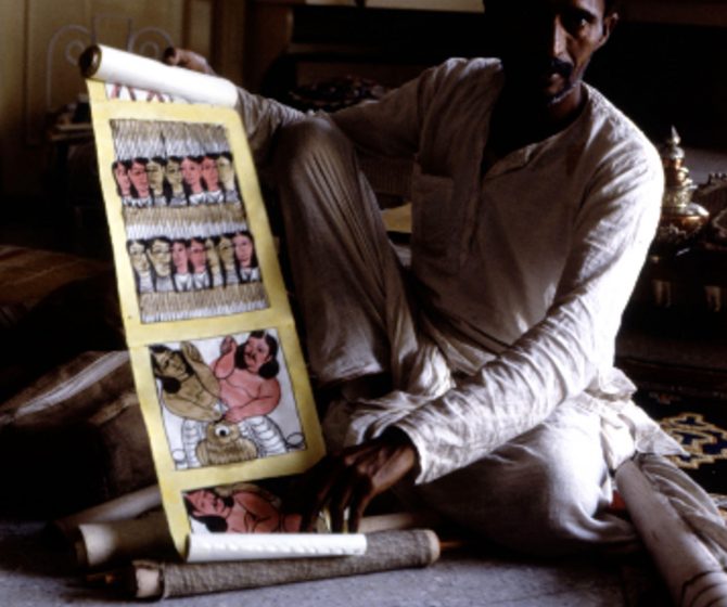 A man in India holds large drawn comic.