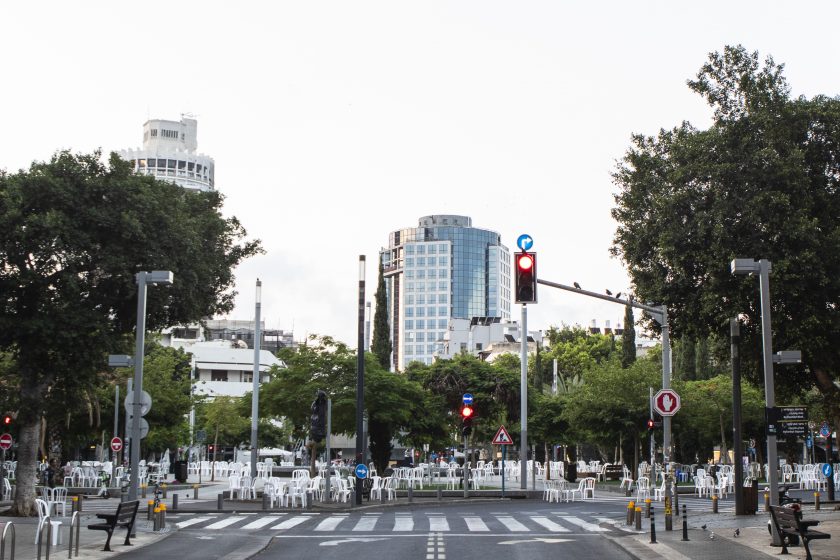 A picture of a crosswalk with buildings and trees in the background