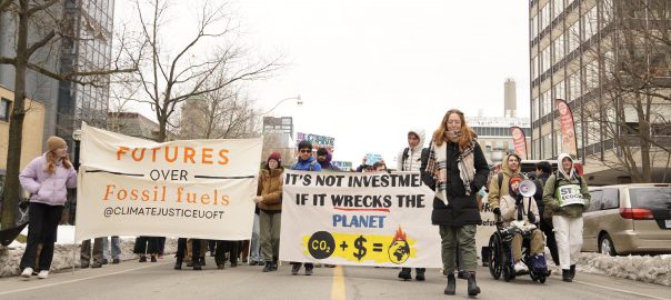 A group of people marching in a street holding signs