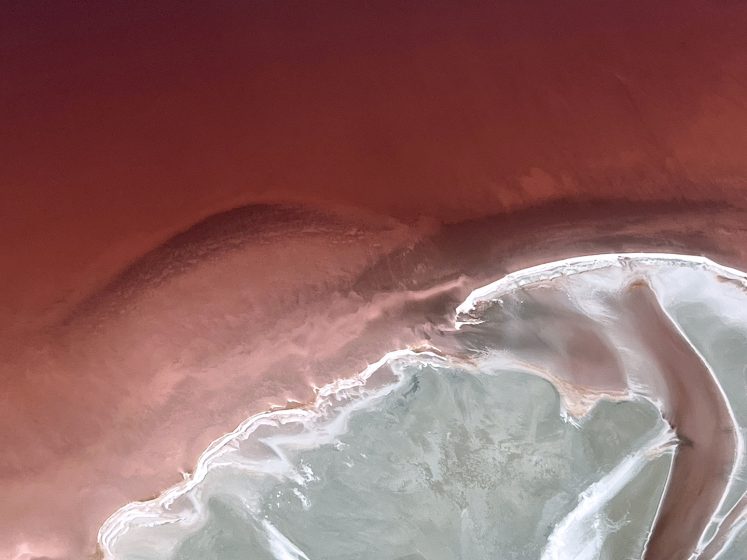 An aerial view of a red sand beach