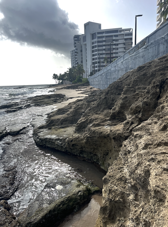 A rocky beach with a building in the background