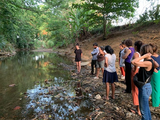 A group of people standing in a line by a pond