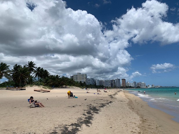 A beach with people on it and a city in the background