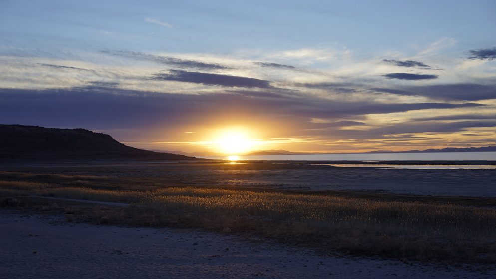 A yellow, blue, and white sunset over a beach