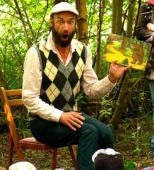 A picture of a man making a shocked face as he reads a book to children out in a forest