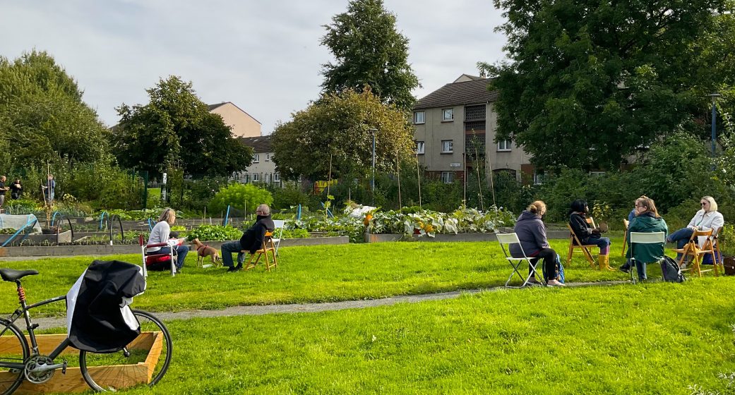 A few people sitting on benches in a green park