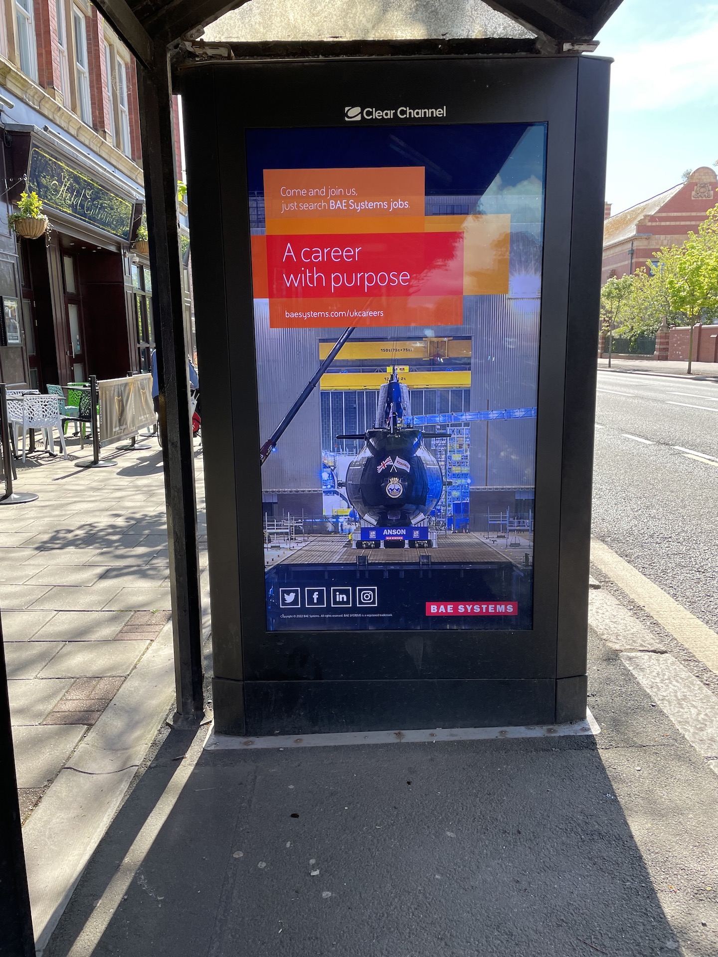 A sign on the side of a bus stop on a sidewalk