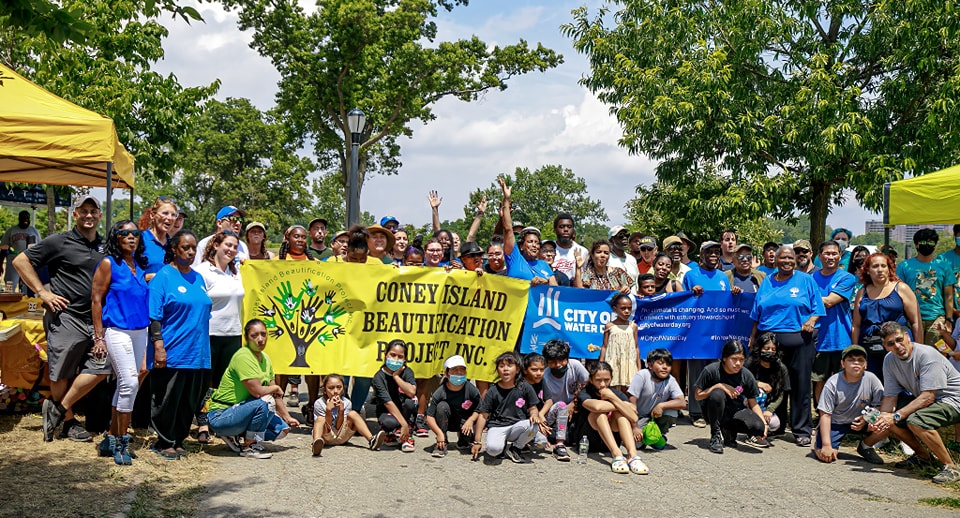 A group of people holding a sign that says "Coney Island Beautification"