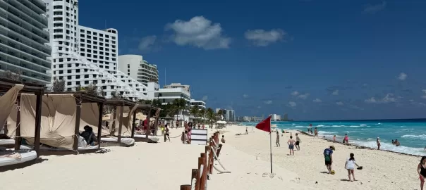 A white sand beach with people walking and playing on the beach