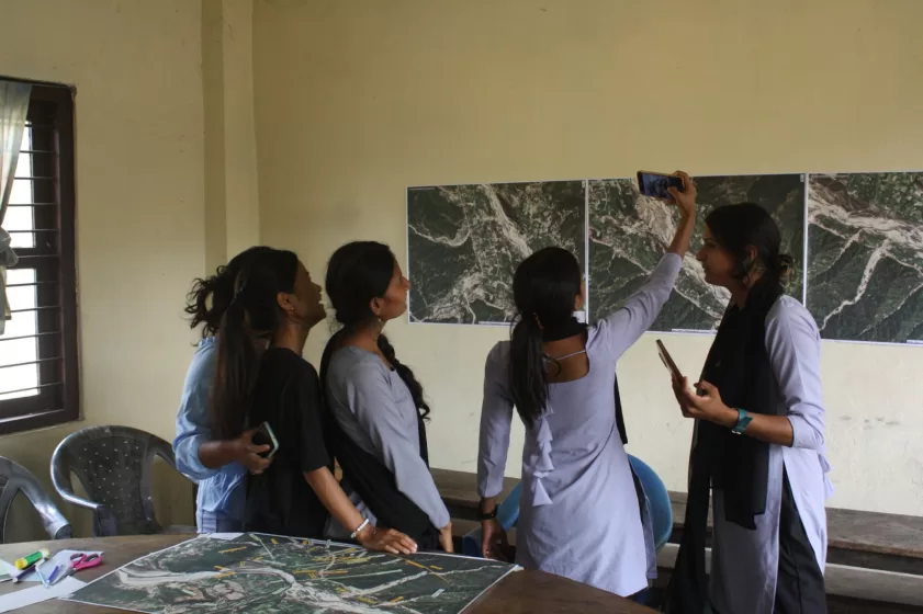 A group of people looking at a piece of art on the wall