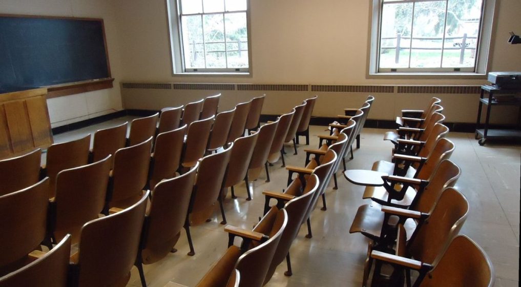 Classroom with windows and wooden chairs and blackboard