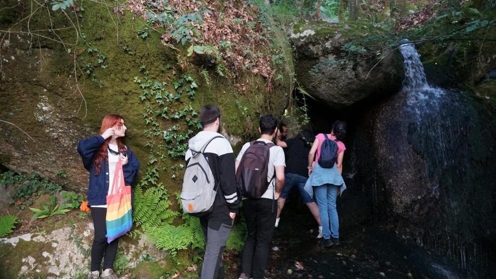 A picture of a group of people outside of a cave