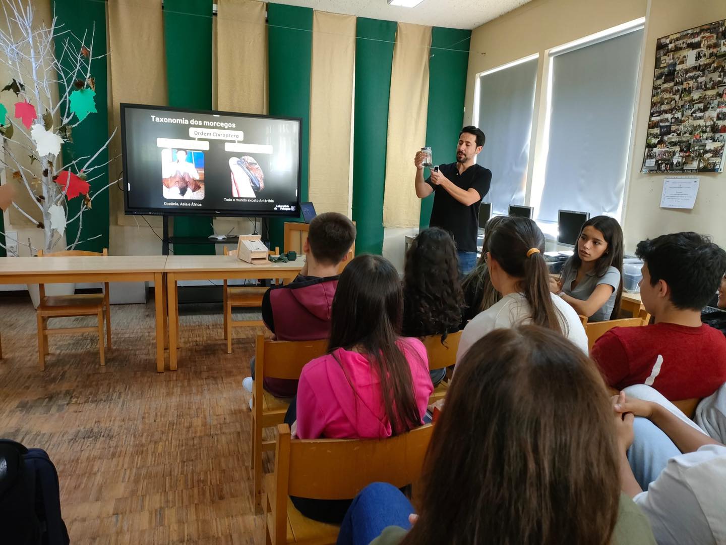 A picture of a group of people watching someone present a slideshow