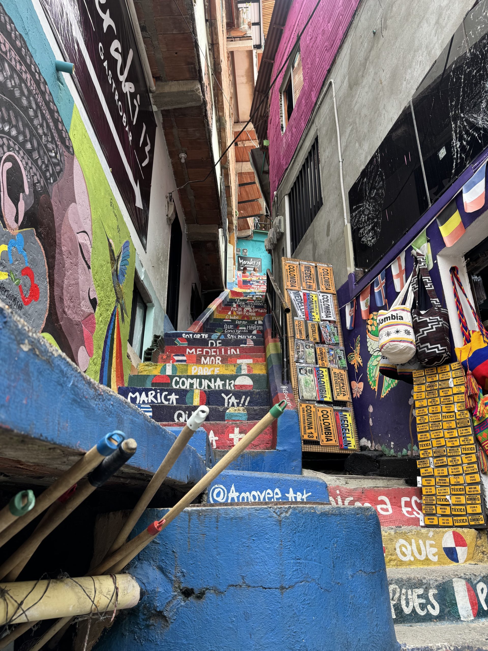 A colorful staircase with various words written on it. The walls surrounding the stairs have colorful murals.